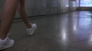 Uzun siyah saçlı genç bir atletik kadın metro boyunca yürüyor. Yavaş Hareket