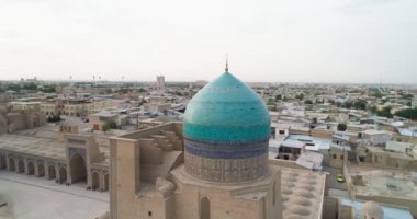 Şafakta Buhara 'daki ünlü anıt kompleksi MIR I Arap Madressa' nın etrafında bir İHA uçuyor. Özbekistan, Hava Görünümü.