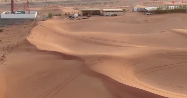 ドローンはUaeの砂漠の砂の中にあるスポーツ複合施設の屋根の上を飛行します 空中風景 — ストック動画