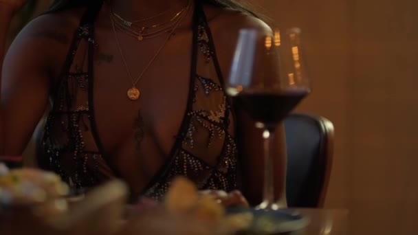 レストランのテーブルでワインを飲む夜のドレスで長い黒い髪をした若いSwarthy女性 スローモーション — ストック動画