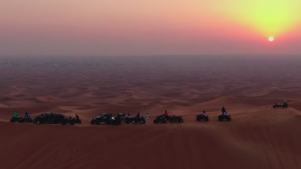 無人機は 日没を背景に砂漠の砂丘の上に立つAtvの上を飛ぶ 空中風景 — ストック動画