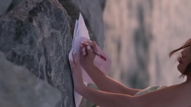 Μια Νεαρή Γυναίκα Ένα Ελαφρύ Φόρεμα Γράφει Ένα Γράμμα Φύλλα — Αρχείο Βίντεο