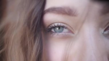 Yüzü gri gözlü ve uzun saçlı genç bir kadın. Kapat, Yavaş Hareket