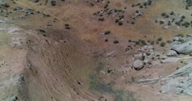 İnsansız hava aracı bulutsuz bir günde dağlarla çevrili kayalık tepelerin üzerinden uçar. Hava Görünümü, Yavaş Hareket