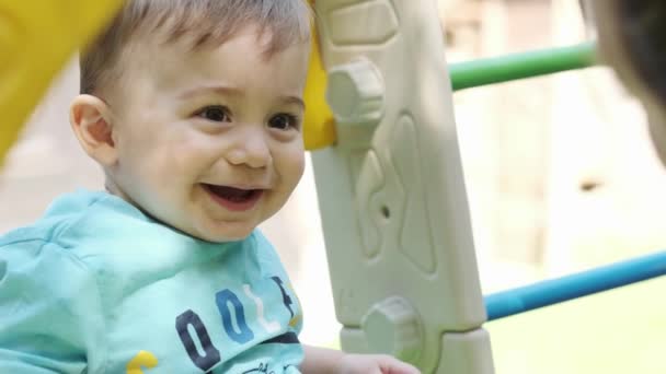 小さな笑顔の少年が遊び場で母親と遊んでいる スローモーション クローズアップ — ストック動画