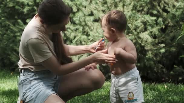 Młoda Matka Szortach Shircie Rozmazuje Ciało Swojego Synka Kremem Odstraszającym — Wideo stockowe