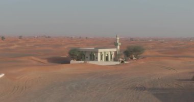 Kum kaplı bir çöl şehrinde bir dron minare yakınında develeri yakalar. Hava Görünümü, Yavaş Hareket.