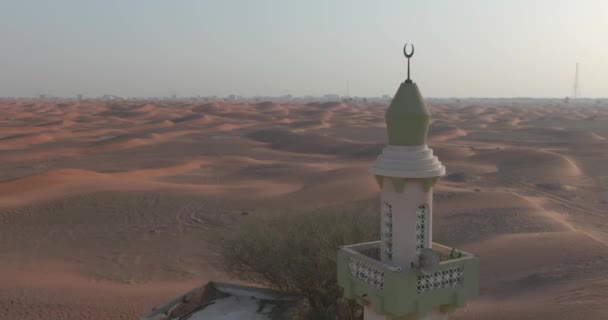 ドローンは砂漠の砂で覆われたミナレットで小さな町の上を飛ぶ エアリアルビュー — ストック動画