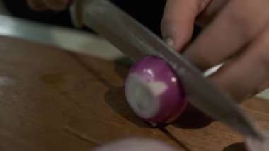 Beyaz eldivenli bir şef kırmızı soğanları kesme tahtasına bir bıçakla keser. Kapat, Yavaş Hareket.