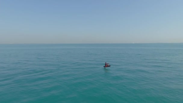 アラブ首長国連邦 ドバイ 2023 ドローンは プライベートヨットの隣のオープン海の電気ホイルボードに乗っている男の上を飛ぶ エアリアルビュー スローモーション — ストック動画