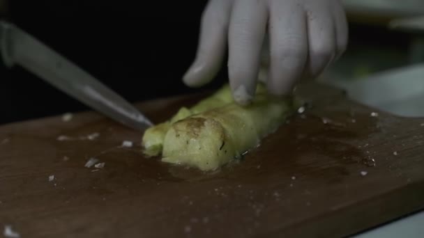 シェフはまな板にナイフでズッキーニの大きな作品をカットします 閉じる スローモーション — ストック動画