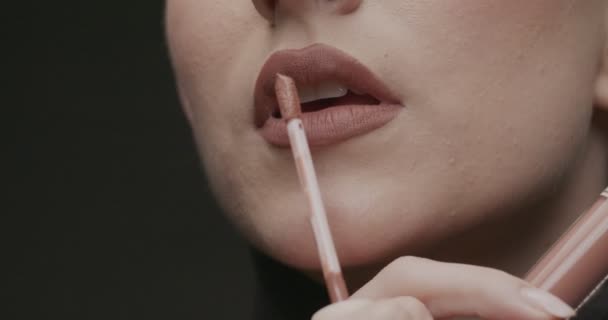 若いエレガントな女性は唇に光沢を当てています 閉じる スローモーション スタジオショット — ストック動画