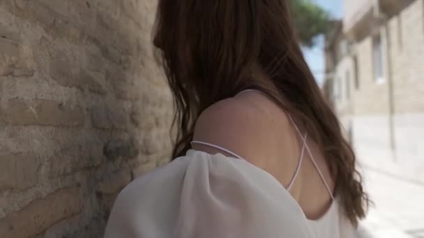 Молодая Женщина Длинными Волосами Белым Сарафаном Идет Вдоль Древней Стены — стоковое видео