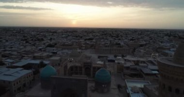 Şafakta eski şehrin ve ünlü anıt kompleksi iKalyan Poi Kalon Kompleksi ve Poi Kalon Minaret n Bukhara 'nın üzerinde bir dron uçar. Hava manzarası, Özbekistan.