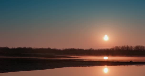 새벽이 관목으로 둘러싸인 호수에 안개가 해진다 — 비디오