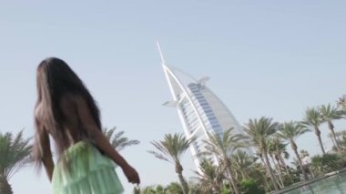 Elbiseli rahat ırklar arası kadın Dubai 'de bir kanaldan geçen bir teknenin pruvasında duruyor. Güzellik, sağlık ve özgüven, yavaş çekim