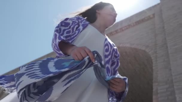 동양식의 장발을 여자가 바람에 나부끼고 모스크 근처에 느리게 우즈베키스탄 — 비디오
