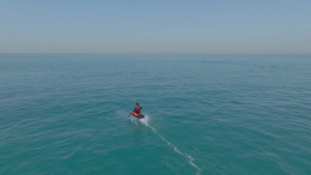 一架无人驾驶飞机在一艘私人游艇旁边的公海上 飞越了一个坐着电翼板航行的人 空中景观 慢动作 — 图库视频影像
