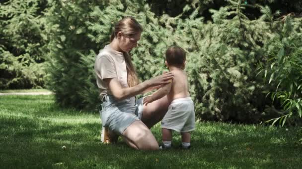 Mladá Matka Šortkách Tričku Potírá Tělo Svého Malého Syna Krémem — Stock video
