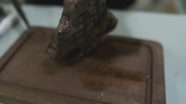 Şef bir bıçakla kesilmiş et parçalarını kesiyor. Yavaş Hareket, Kapat.