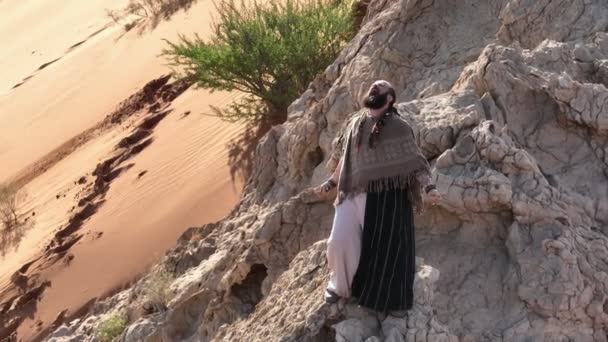 Человек Посохом Руке Одеждой Шамана Стоит Скале Среди Песков Пустыни — стоковое видео
