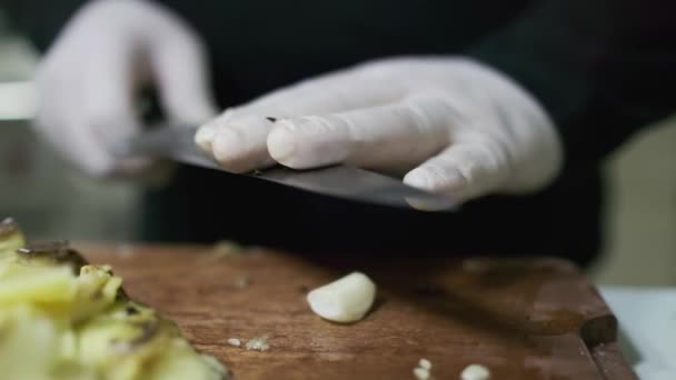Een Chef Kok Witte Handschoenen Snijdt Knoflook Een Snijplank Met — Stockvideo