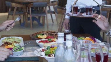 İnsanlar restoranda bir masaya oturur ve yemek yerler. Kapat, Yavaş Hareket.