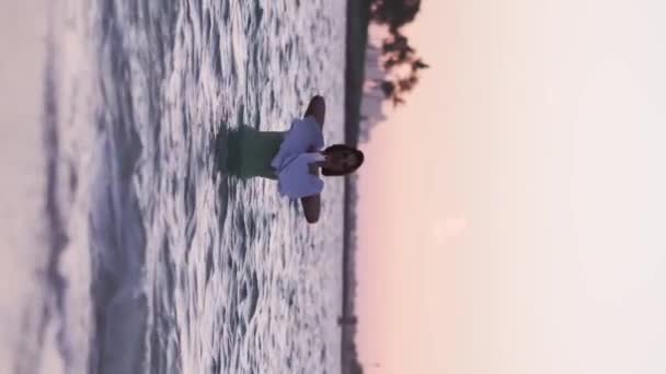 Günbatımının Arkaplanına Karşı Elbise Giymiş Genç Bir Kadın Okyanusun Sularında — Stok video