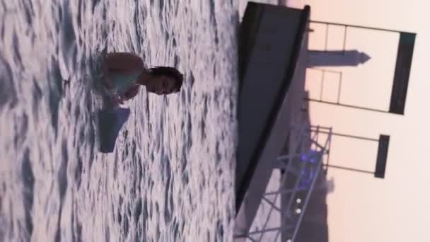 Μια Νεαρή Γυναίκα Ένα Ελαφρύ Φόρεμα Στέκεται Στη Θάλασσα Στο — Αρχείο Βίντεο