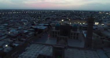 Şafakta eski şehrin ve ünlü anıt kompleksi iKalyan Poi Kalon Kompleksi ve Poi Kalon Minaret n Bukhara 'nın üzerinde bir dron uçar. Hava manzarası, Özbekistan.
