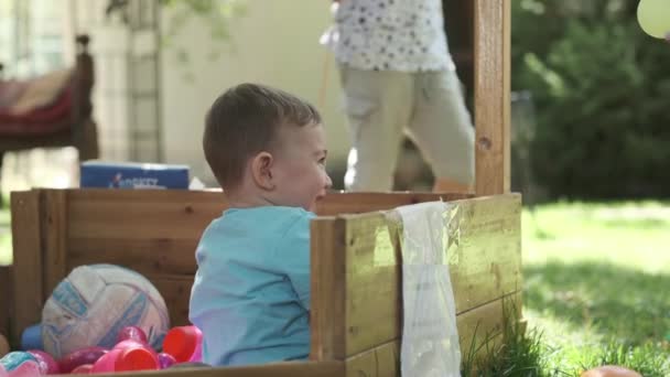 Маленький Европейский Мальчик Играет Красочными Гадостями Деревянном Доблести Улице Летом — стоковое видео