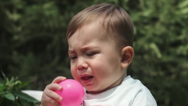 Маленький Мальчик Шортах Шортах Сидит Траве Парке Играет Пластиковым Мячом — стоковое видео