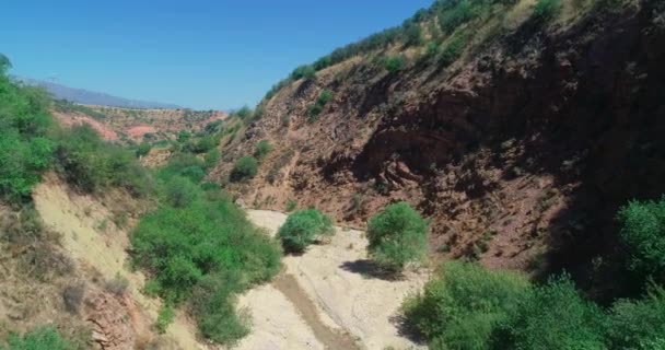 一架无人驾驶飞机在山间干涸的河床上飞行 空中景观 慢动作 — 图库视频影像