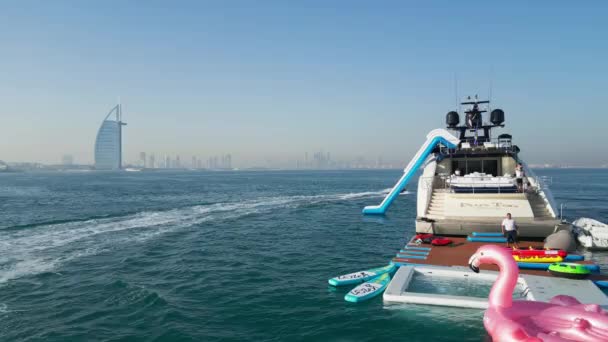 阿联酋 3月20日2023 一架无人驾驶飞机在人们乘坐喷气式滑翔机的海面上飞行 旁边是一艘以迪拜为背景的游艇 空中景观 慢动作 — 图库视频影像