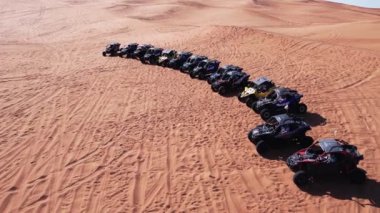 Bir dron çöl kum tepeciğinde duran fayton kervanının üzerinden uçuyor. Hava Görünümü.