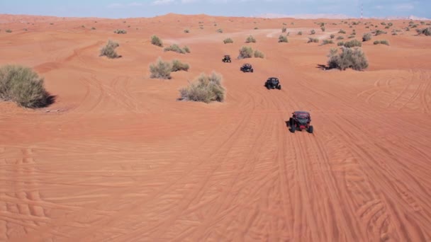 ドローンは砂漠の砂を運転するバギーのキャラバンを飛ぶ エアリアルビュー — ストック動画