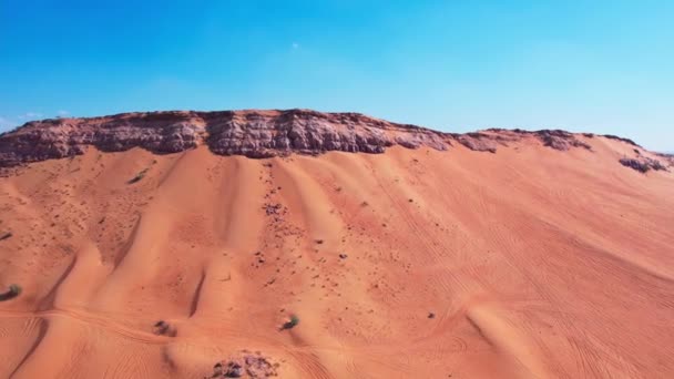 無人機は砂漠の砂丘の間に孤独な岩の上を飛ぶ エアリアルビュー — ストック動画