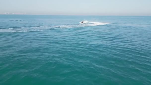 アラブ首長国連邦 ドバイ 2023 ヨットの隣の海でジェットスキーに乗っている人々をドローンが飛ぶ エアリアルビュー スローモーション — ストック動画