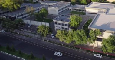 İnsansız hava aracı ağaçlarla çevrili evlerin üzerinden uçuyor. Gündüz vakti Summer City 'de. Hava görünümü.