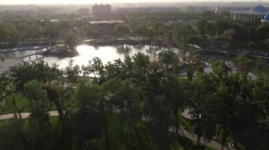 İnsansız hava aracı yaz günü şehir parkında uçuyor. Hava görünümü.