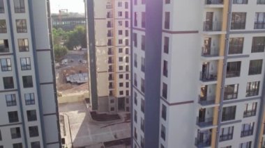 İnsansız hava aracı güneşli yaz gününde apartmanların üzerinden uçuyor.