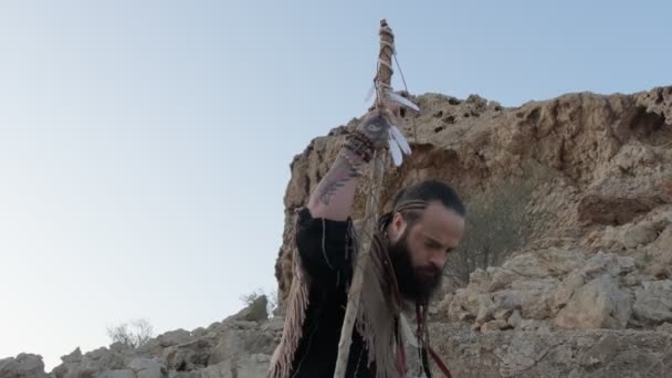 Человек Посохом Руке Одеждой Шамана Стоит Скале Среди Песков Пустыни — стоковое видео