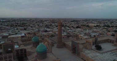 Şafak vakti Buhara 'daki ünlü Kalyan Poi Kalon Kompleksi ve Poi Kalon Minaret, Poi Kalan veya Po-i-Kalyan anıtında bir İHA uçar. Hava manzarası, Özbekistan