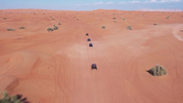 ドローンは砂漠の砂を運転するバギーのキャラバンを飛ぶ エアリアルビュー — ストック動画