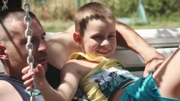 Teenager Leží Svém Mladém Otci Houpačce Parku Slunečného Dne Mluví — Stock video