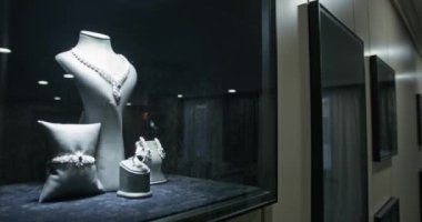Rüzgarda mücevher olan bir kuyumcunun vitrini. Yüzükler, bilezikler, kolyeler. Yavaş çekim, Yakın çekim.