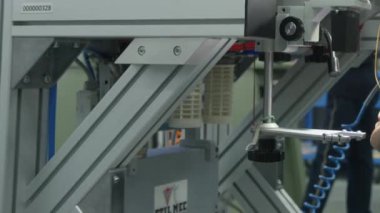 Genç bir adam atölyedeki bir makinede çalışıyor. Kapat, Tohum Hareketi