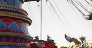 Taşkent, Özbekistan - 84 2022: Lunaparka gelen ziyaretçiler atlıkarıncaya biniyor. Yavaş Hareket.