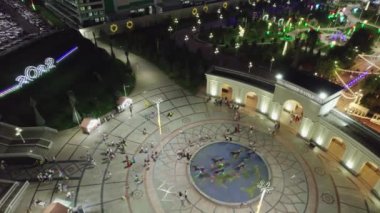 Bir dron lunaparkın üzerinde atlı karınca ve dönme dolap ile uçuyor. Gece, hava manzaralı.