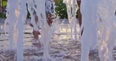 Bir yaz günü parkta bir çeşmenin üzerinde yürüyen insanların ayakları. Yavaş Hareket.